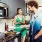 man cooks as his wife sits on kitchen counter with a glass of wine