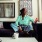 woman sits on her couch and looks at her phone