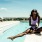 womn sits at the pool with a drink